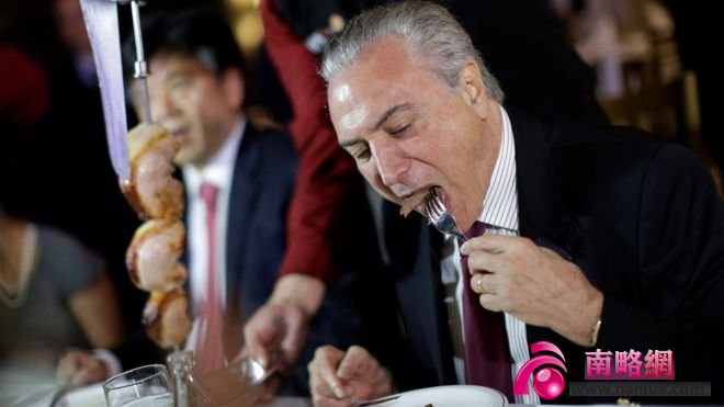 Brazil's President Michel Temer eats barbecue in a steak house after a meeting with ambassadors of meat importing countries of Brazil, in Brasilia, Brazil March 19, 2017.