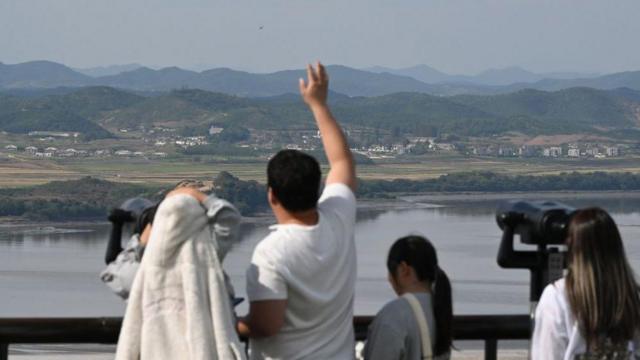 Visitors use binoculars to look at the North Korean side of the Demilitarised Zone (DMZ) dividing the two Koreas